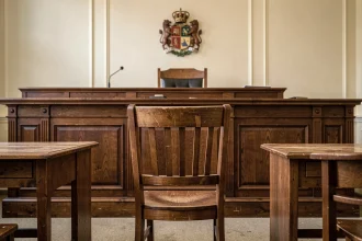 Chaise vide devant le banc d'un juge dans une salle d'audience, symbolisant l'absence à une convocation devant le juge des enfants