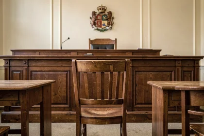 Chaise vide devant le banc d'un juge dans une salle d'audience, symbolisant l'absence à une convocation devant le juge des enfants